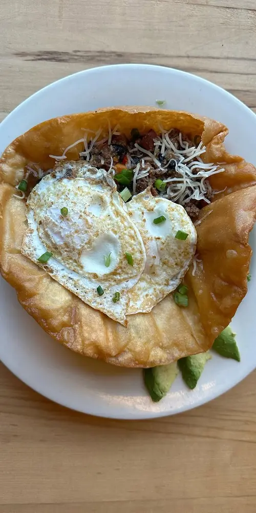 Beef Chili on a Crispy Fried Tortilla with Over Easy Eggs, Cheddar Cheese, and Avocado Ranch Salad G